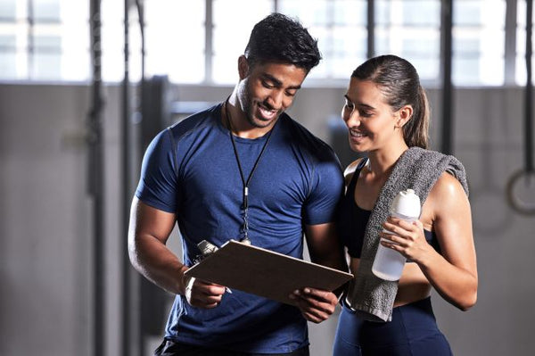 Personal training session where a coach and client discuss workout results
